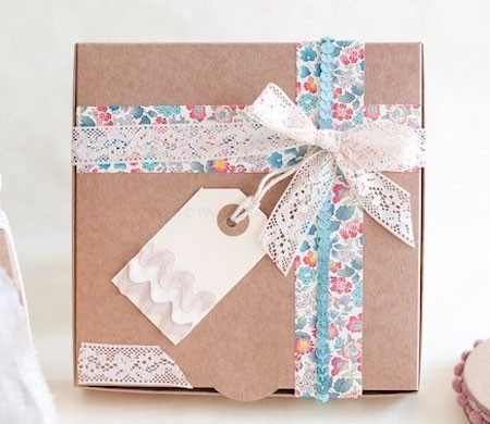 Graziosa scatola regalo con fiocco e nastro floreale